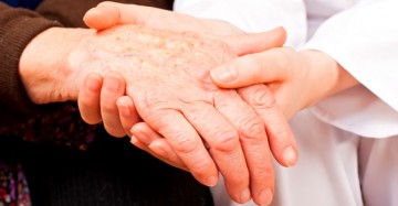 Young doctor holds the elderly woman hands